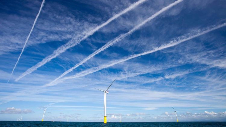 Contrails over  wind turbines in the Walney offshore wind farm.