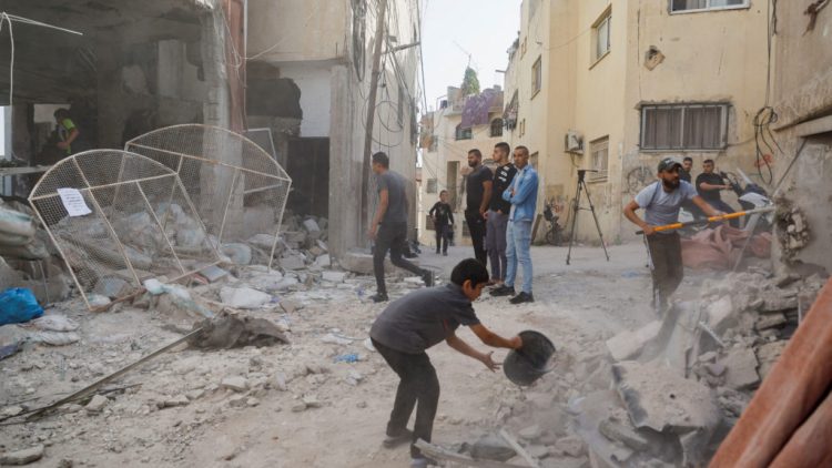 Palestinians remove rubble from a mosque which was hit in an Israeli air strike, in Jenin