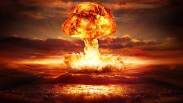 testing of atomic bomb over ocean with mushroom clouds – red destroy