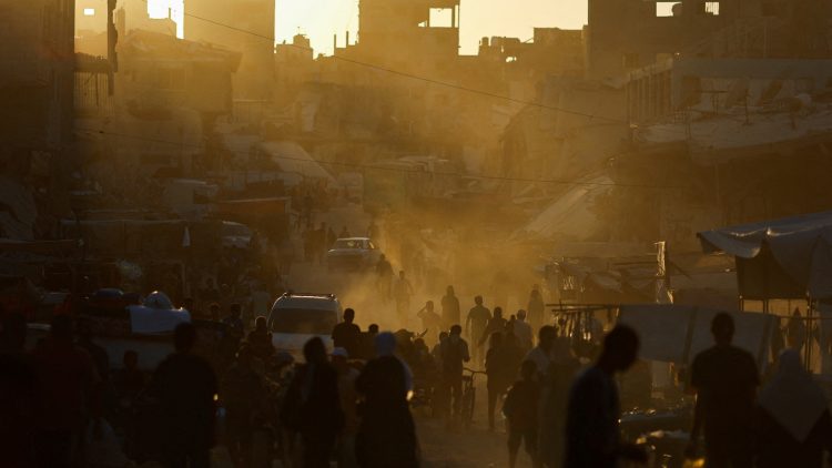 People walk at the remains of a market after an Israeli strike, in Khan Younis